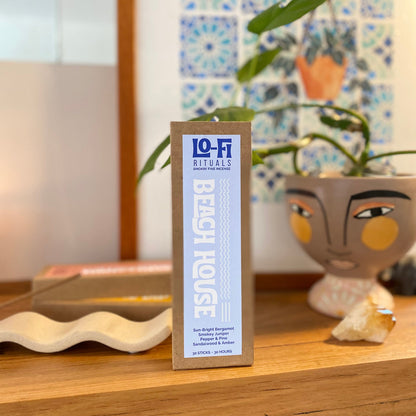 Lo-Fi Rituals 'Beach House' incense packaging front on centre on a timber surface with decorative elements in the background.