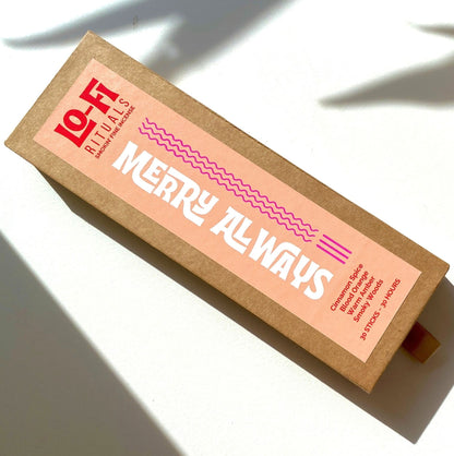 A rectangular kraft paper box of Lo-Fi Rituals incense sits on a sunlit white background, featuring a modern, bold label in eye-catching peach, red and hot pink. 