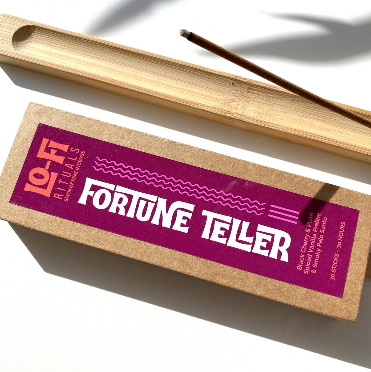 Boldly labelled Lo-Fi Rituals Fortune Teller Incense Box next to a bamboo incense holder burning incense