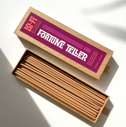 An open box of Lo-Fi Rituals Fortune Teller Incense in the sun on a white background with shadows