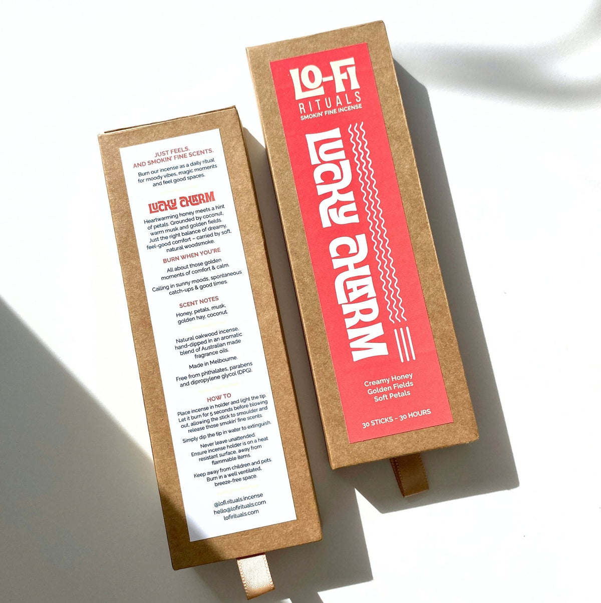 A side by side of the front and back of Lo-Fi Rituals Lucky Charm incense, the bold modern front label is visible, as is the back of pack label with scent description for creamy honey, golden fields and soft petals