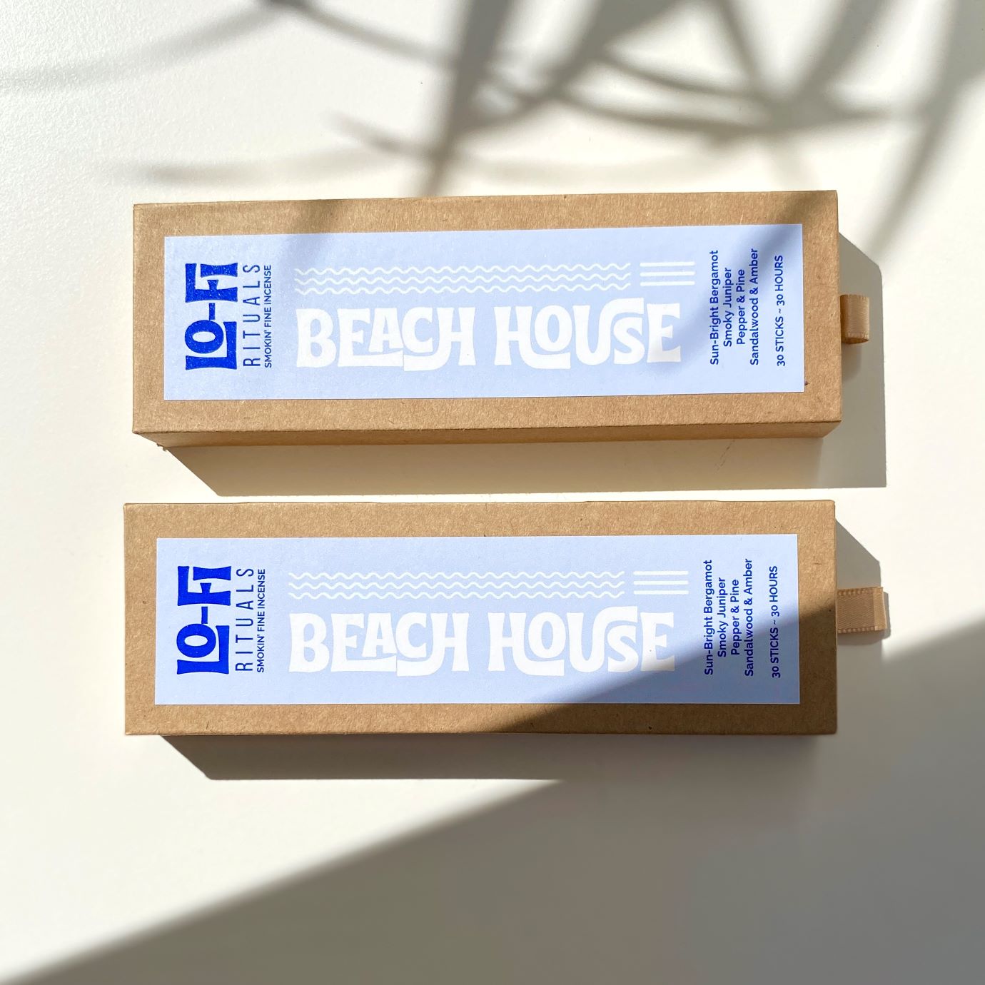Sunlit white background with cinematic shadows featuring two boldly labelled boxes of Lo-Fi Rituals Beach House incense