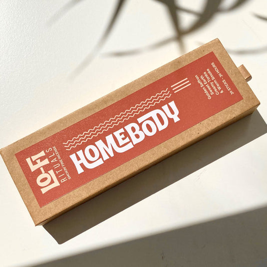 Hero image of Lo-Fi Rituals Homebody incense in bright sunlight on a white background, casting moody aesthetic shadows