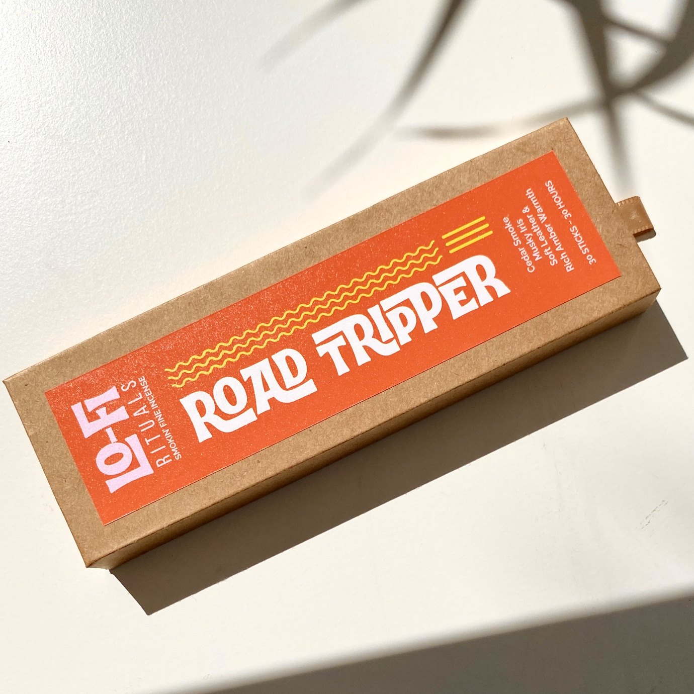 Flatlay of box of Lo-Fi Rituals incense Road Tripper scent on sunlit light background with decorative shadows