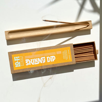 Open box Lo-Fi Rituals Skinny Dip incense next wooden incense holder burrning incense with curling smoke 